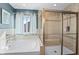 Bright bathroom featuring a glass enclosed step-in shower, and large soaking tub with window at 377 Morningside Dr, Brownsburg, IN 46112