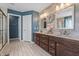 Well-lit bathroom showcasing double sinks with dark wood cabinets and decorative wood accent wall at 377 Morningside Dr, Brownsburg, IN 46112