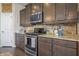 Well-equipped kitchen showcasing stainless steel appliances, granite countertops, and tile backsplash at 377 Morningside Dr, Brownsburg, IN 46112