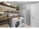 Practical laundry room with overhead shelving, folding table, and modern washing machine at 377 Morningside Dr, Brownsburg, IN 46112