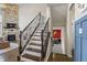 Elegant staircase with dark wood treads, iron railings, and a view into the living room at 377 Morningside Dr, Brownsburg, IN 46112
