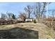Backyard with trees and a patchy grass lawn surrounded by a wooden fence at 3910 E 34Th St, Indianapolis, IN 46218