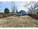Backyard with trees and a patchy grass lawn surrounded by a wooden fence at 3910 E 34Th St, Indianapolis, IN 46218