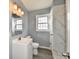 Bathroom with sleek gray walls, vanity with sink, commode and shower with decorative marble tile at 3910 E 34Th St, Indianapolis, IN 46218