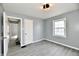 Bright bedroom featuring wood-look floors, large window for natural light, and easy access to hallway at 3910 E 34Th St, Indianapolis, IN 46218