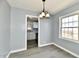 The dining room features modern hanging light fixture and access to the kitchen with matching gray walls at 3910 E 34Th St, Indianapolis, IN 46218