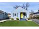 Charming light blue house with a bright yellow door, gray trim, and a green front yard at 3910 E 34Th St, Indianapolis, IN 46218