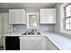 Updated kitchen featuring marbled countertops, stainless steel sink, and white cabinets and appliances at 3910 E 34Th St, Indianapolis, IN 46218