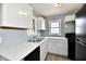 Charming kitchen with stainless steel sink, white marbled countertops, and black gas range at 3910 E 34Th St, Indianapolis, IN 46218
