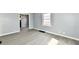 Living room with gray walls, modern flooring, white trim, and a window letting in natural light at 3910 E 34Th St, Indianapolis, IN 46218