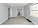 Living room with gray walls, modern flooring, white trim, and a window letting in natural light at 3910 E 34Th St, Indianapolis, IN 46218