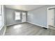 Living room with gray walls, modern flooring, white trim, and a window letting in natural light at 3910 E 34Th St, Indianapolis, IN 46218