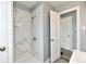 Shower with decorative marble-look tile and modern fixtures, located off the home's bathroom at 3910 E 34Th St, Indianapolis, IN 46218