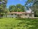 Large backyard with a white brick house, awning, and a concrete patio at 5324 Mann Rd, Indianapolis, IN 46221
