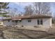 Rear view of a freshly painted white brick ranch with a patio at 5324 Mann Rd, Indianapolis, IN 46221