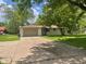 Charming single-story home featuring a convenient two-car garage and a sprawling front yard at 5324 Mann Rd, Indianapolis, IN 46221