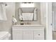 Modern bathroom with white vanity, large mirror, and shower at 5704 E 16Th St, Indianapolis, IN 46218