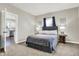 Cozy bedroom with a queen bed, carpet flooring, and view into kitchen at 5704 E 16Th St, Indianapolis, IN 46218