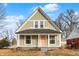 Charming craftsman style home with a gray exterior, pink door and front porch at 5704 E 16Th St, Indianapolis, IN 46218