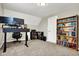 Home office with standing desk, dual monitors, and built-in shelving at 5704 E 16Th St, Indianapolis, IN 46218