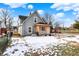 Gray house with pink door, wood siding and snowy yard at 5704 E 16Th St, Indianapolis, IN 46218