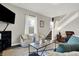 Living area with a dark sofa, cream chairs, and a view of the staircase at 5704 E 16Th St, Indianapolis, IN 46218