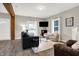 Spacious living room with a dark sofa, glass coffee table, and hardwood floors at 5704 E 16Th St, Indianapolis, IN 46218