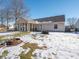 Spacious backyard with covered patio, fire pit, and snow-covered lawn at 6264 Whitaker Farms Dr, Indianapolis, IN 46237