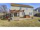 Grassy backyard with a wooden deck featuring a hot tub, grill, and pergola, great for outdoor relaxation and entertaining at 6623 Pasco Ln, Plainfield, IN 46168