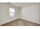 Clean, minimalist bedroom with a large window, neutral carpet, and white walls, providing a blank canvas for personalization at 6623 Pasco Ln, Plainfield, IN 46168