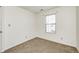 Simple bedroom with a large window, neutral carpet, and white walls, providing a blank canvas for personalization at 6623 Pasco Ln, Plainfield, IN 46168