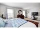 Bright and airy main bedroom with a dresser, TV, carpet and a comfortable bed with soft hues at 6623 Pasco Ln, Plainfield, IN 46168