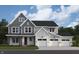 Two-story home with gray and white siding, three-car garage, and red front door at 6871 Oakdale Ln, Avon, IN 46123
