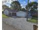 View of a detached two-car garage with a gravel driveway and fenced yard at 733 S Emerson Ave, Indianapolis, IN 46203