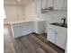 White kitchen with light gray vinyl flooring and stainless steel appliances at 733 S Emerson Ave, Indianapolis, IN 46203