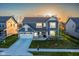 Beautiful two-story home with lush lawn, landscaping, and a two-car garage in a quiet neighborhood, lit by the rising sun at 9812 Ridgecrest Ln, McCordsville, IN 46055
