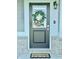Inviting front door with a wreath, decorative light fixture, a 'welcome' mat, and stylish siding at 9812 Ridgecrest Ln, McCordsville, IN 46055