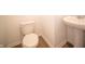 Clean half bathroom featuring pedestal sink, a modern toilet, and stylish wood-look flooring at 101 Ames Dr, Whiteland, IN 46184
