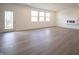 Bright living room featuring three windows, a modern fireplace, and wood-look flooring at 101 Ames Dr, Whiteland, IN 46184