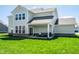 Backyard view featuring covered patio with outdoor seating, grill, and manicured lawn at 11034 Saddlebred Dr, Indianapolis, IN 46239