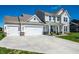 Bright home featuring a two-car garage with a long driveway, a charming porch, and well-manicured lawn at 11034 Saddlebred Dr, Indianapolis, IN 46239