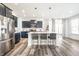 Modern kitchen featuring a large island with bar stools, stainless steel appliances, and sleek cabinetry at 11034 Saddlebred Dr, Indianapolis, IN 46239