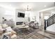 Open-concept living room featuring stylish furniture, a fireplace, and a staircase that connects the floors at 11034 Saddlebred Dr, Indianapolis, IN 46239