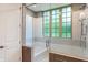 Bright bathroom featuring a tub with glass enclosure and large window with natural light at 11710 Cold Creek Ct, Zionsville, IN 46077