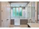 Bright bathroom featuring a tub with glass enclosure and large window with natural light at 11710 Cold Creek Ct, Zionsville, IN 46077