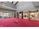 Spacious game room with red carpet, basketball hoop, and access to multiple living areas at 11710 Cold Creek Ct, Zionsville, IN 46077
