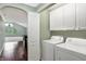 Laundry room with a washer, dryer, and storage cabinets, leading into the living room at 11710 Cold Creek Ct, Zionsville, IN 46077