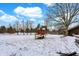 Snow-covered backyard featuring a charming playhouse, nestled among mature trees at 1307 W 161St St, Westfield, IN 46074