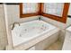 Bathroom featuring whirlpool tub beneath a window with tiled surround and wood trim provides a relaxing and visually pleasing focal point at 1307 W 161St St, Westfield, IN 46074