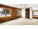Bright bedroom with wood paneled accent wall, large windows, neutral carpet, ceiling fan, and wood door creates a cozy retreat at 1307 W 161St St, Westfield, IN 46074